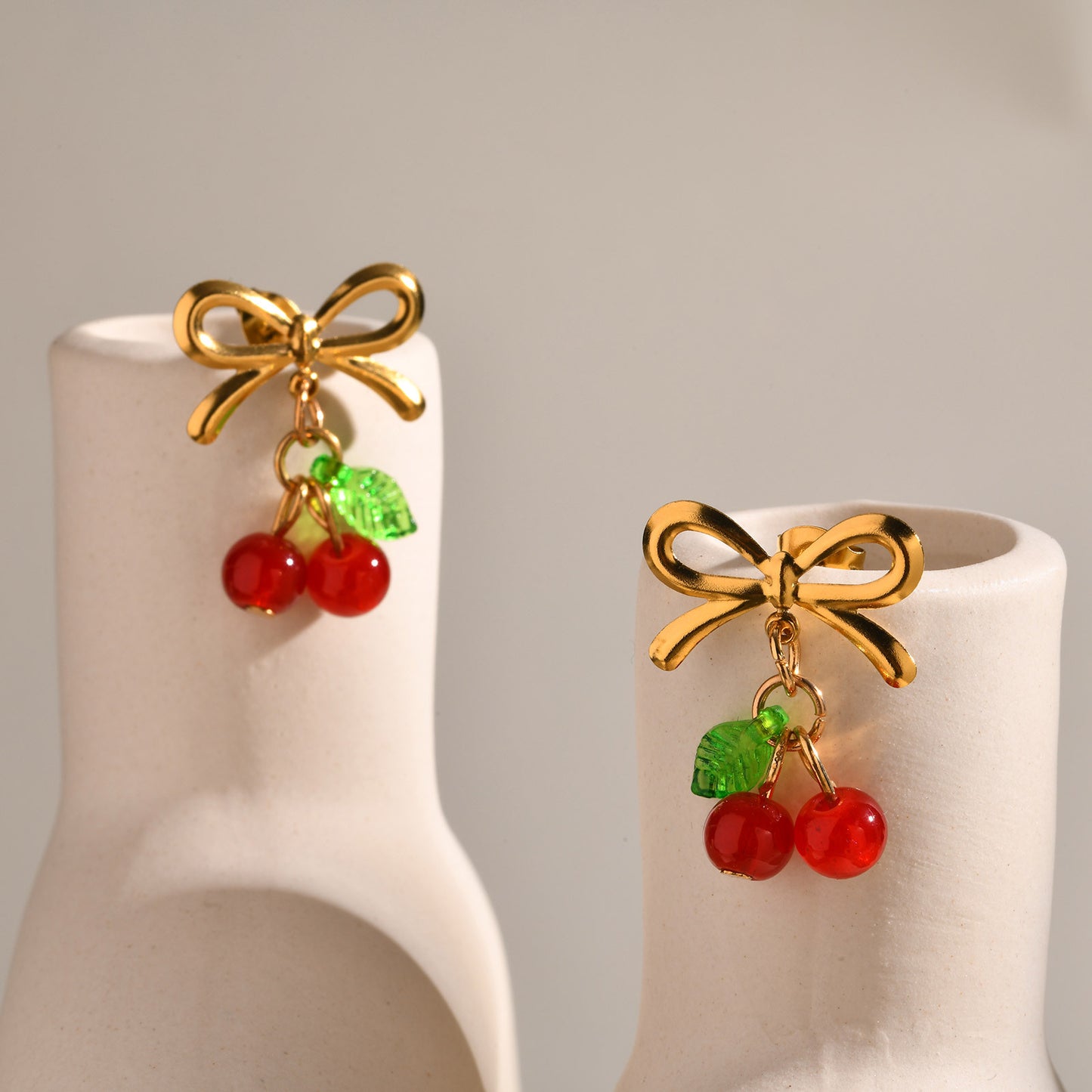 E3637 Aretes moño cereza acero inoxidable resina 2.5cm