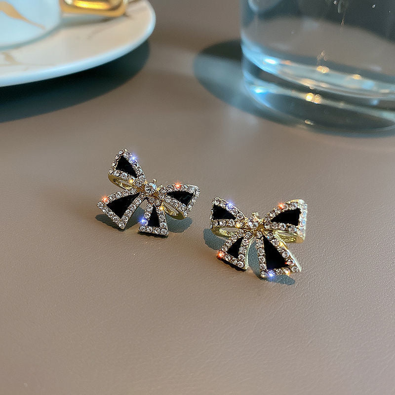 E868 Aretes moño negro brillante poste de plata 1.5cm