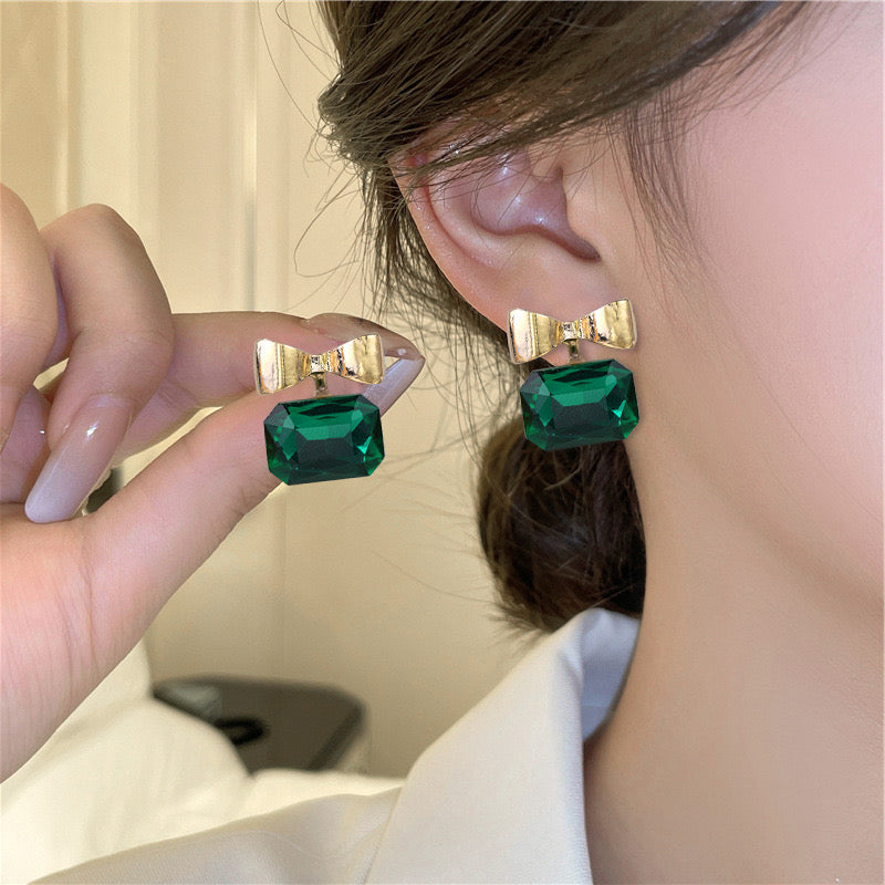 E1919 Aretes moño cristal verde esmeralda poste de plata 1.5cm
