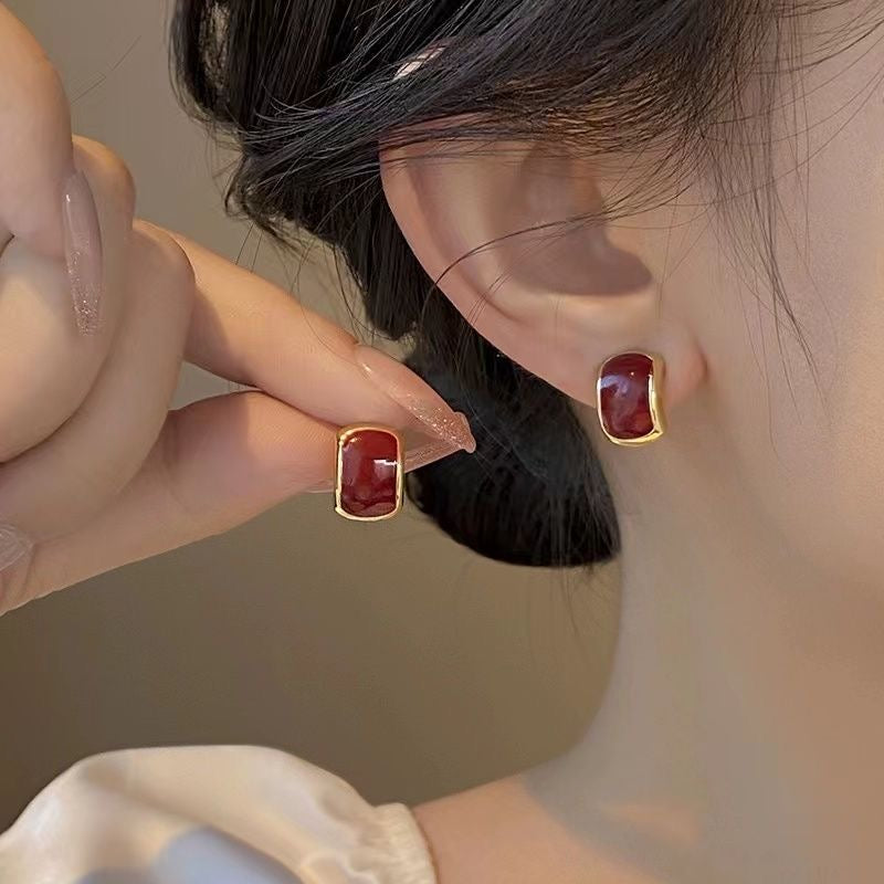 E7375 Aretes rojos con margen dorado de aleacion