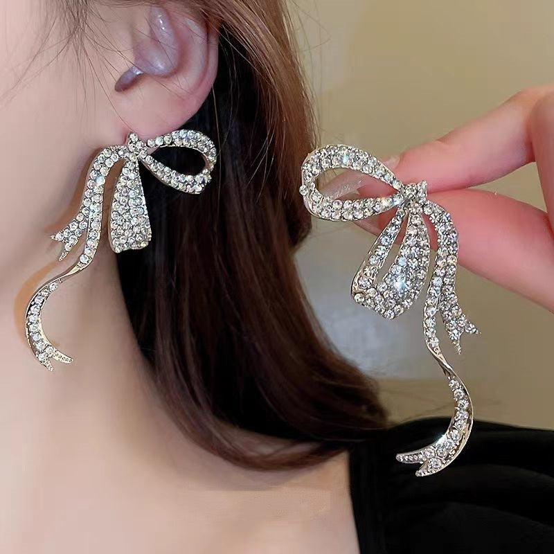 E4532 Aretes moño plateado brillante fiesta aleacion 6.5cm