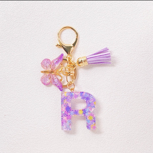 K145 Llavero letra R morada mariposa acrílico