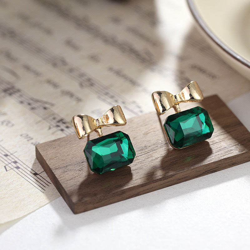 E1919 Aretes moño cristal verde esmeralda poste de plata 1.5cm