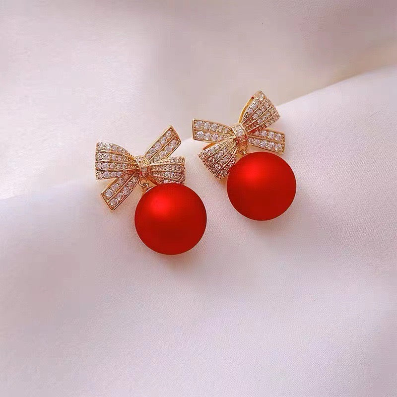 E2245 Aretes moño perla roja zirconia 2.5cm